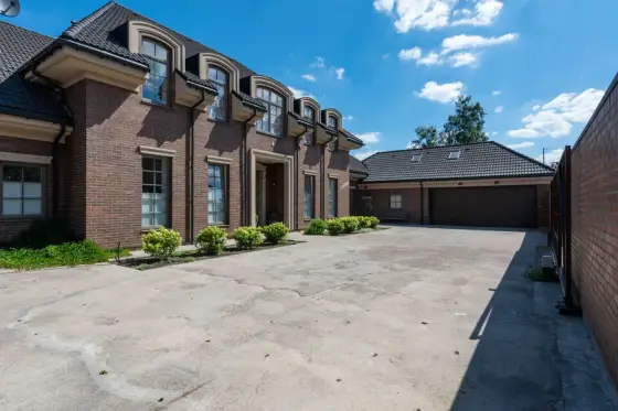 Brick townhomes beside a wide concrete parking apron
