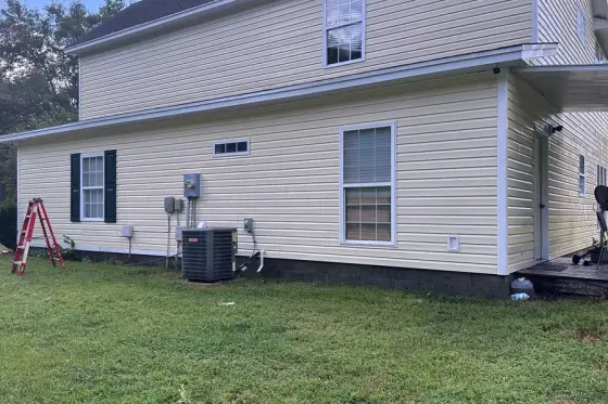 The same house after the wash, siding back to clean cream, Iron Standard job photo